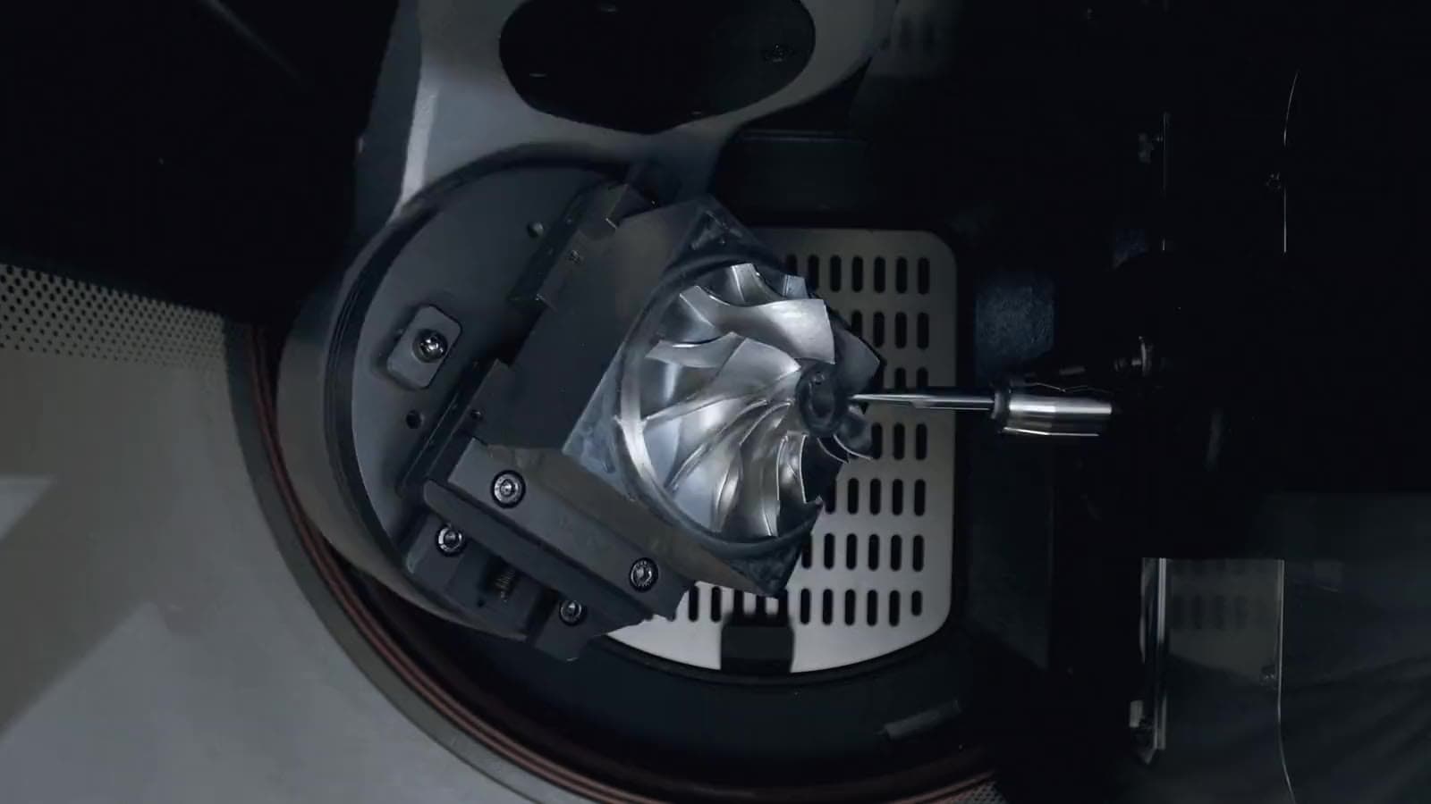 A 5-axis trunnion holding a precision part beneath a milling spindle